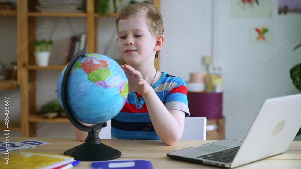 Boy rotate globe, investigate world map at home desk Spbas. Young boy student study geography Boy rotate globe, investigate world map at home desk Spbas. Young boy student study geography
