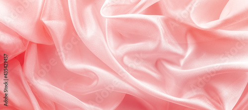 pink organza fabric draped with large folds, delicate textile background photo