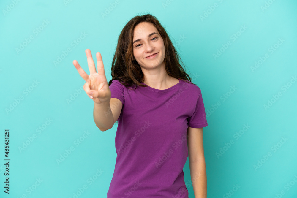 Young caucasian woman isolated on blue background happy and counting three with fingers Young caucasian woman isolated on blue background happy and counting three with fingers