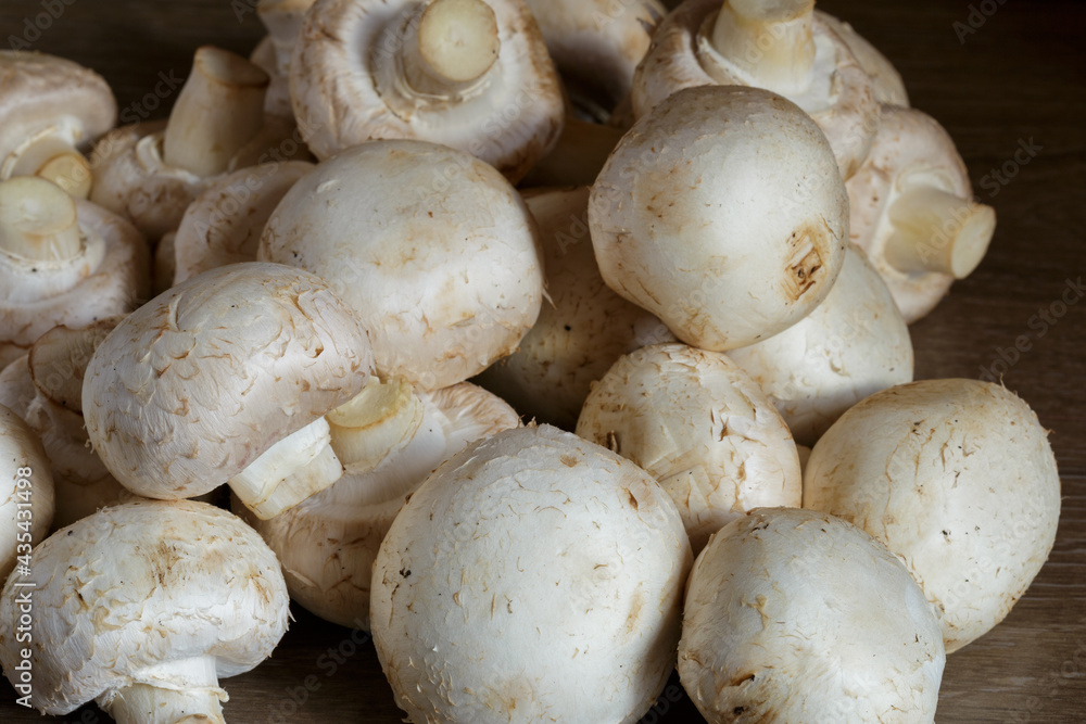 The fresh champignon mushrooms ready for cooking. A top view closeup of fresh mushrooms. The fresh champignon mushrooms ready for cooking. A top view closeup of fresh mushrooms.