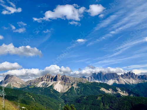 View and Panorama with blue sky and clouds of the peaks of the dolomites in South Tyrol in Italy in the sun.