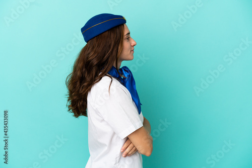 Airplane stewardess woman isolated on blue background in lateral position
