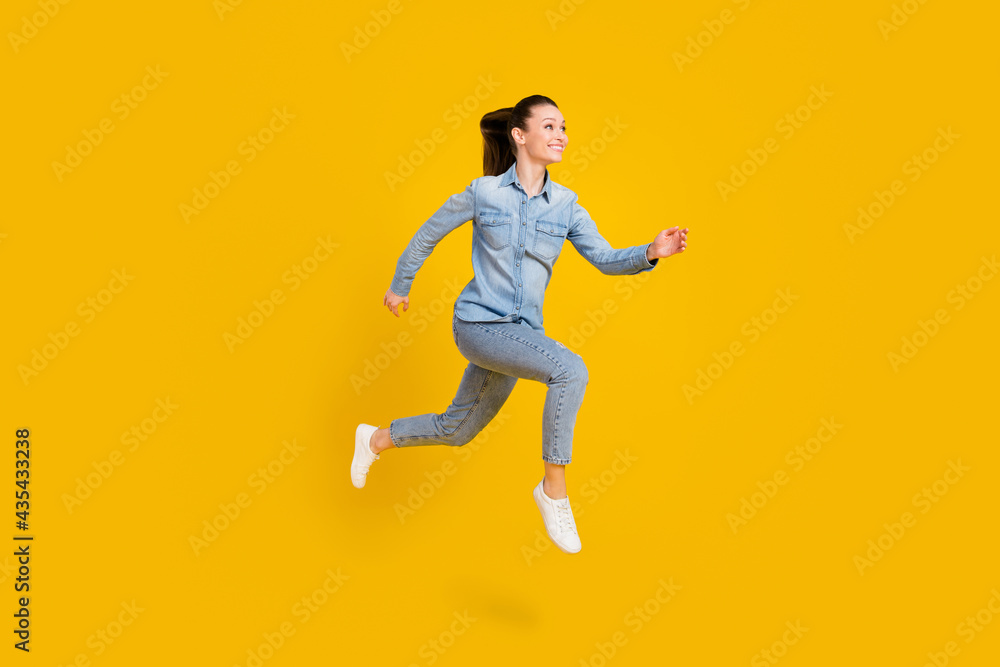 Full size profile side photo of charming young nice woman look run jump up empty space isolated on yellow color background