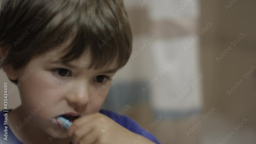 Close-up Portrait Young Little Boy Brushing Her Teeth in Bathroom Looking at Mirror Reflection. Daily Routine Dental Hygiene. Happy Portrait Cute Caucasian Toothless Child Brushing Teeth in Bathroom. Close-up Portrait Young Little Boy Brushing Her Teeth in Bathroom Looking at Mirror Reflection. Daily Routine Dental Hygiene. Happy Portrait Cute Caucasian Toothless Child Brushing Teeth in Bathroom.