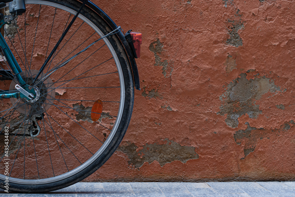 Rear bike wheel on orange worn wall. Old style cycling SC