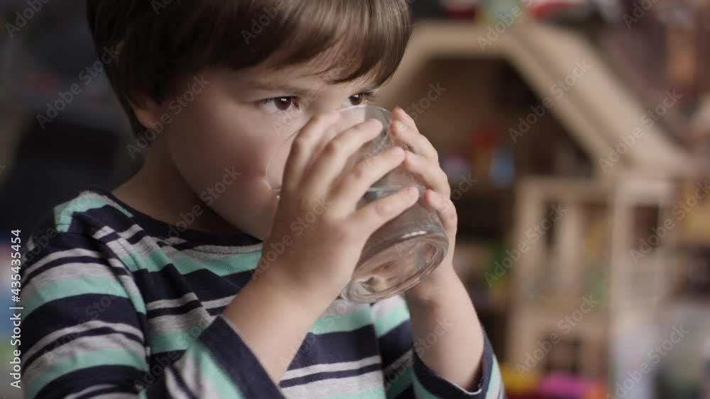 Cute Child Boy Drinking Glass Fresh Transparent Pure Filtered Mineral Water at Home. Slow Motion Little Boy Drinks Water. Close up Kid drinking Cup Water Healthy Body Care. Healthy lifestyle Children. Cute Child Boy Drinking Glass Fresh Transparent Pure Filtered Mineral Water at Home. Slow Motion Little Boy Drinks Water. Close up Kid drinking Cup Water Healthy Body Care. Healthy lifestyle Children.