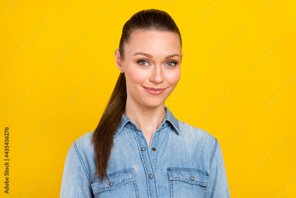 Photo of attractive young nice lady ponytail hair good mood wear denim shirt isolated on shine yellow color background Photo of attractive young nice lady ponytail hair good mood wear denim shirt isolated on shine yellow color background