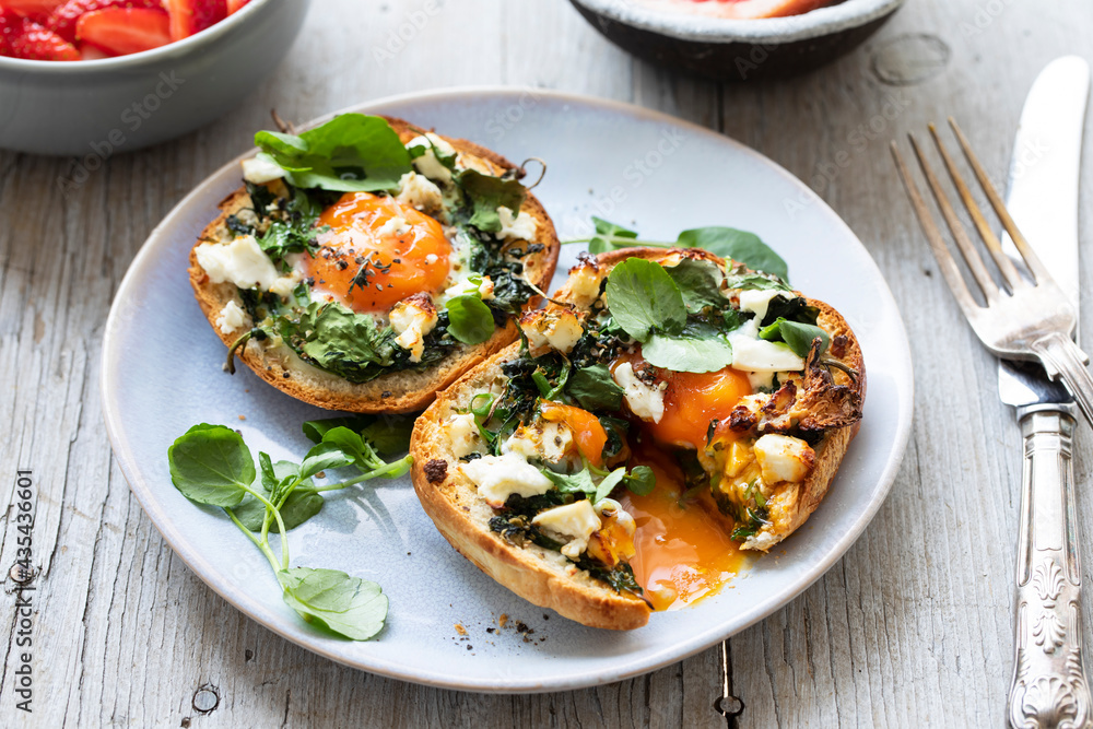 Eggs baked inside brioche bun with watercress and feta Eggs baked inside brioche bun with watercress and feta