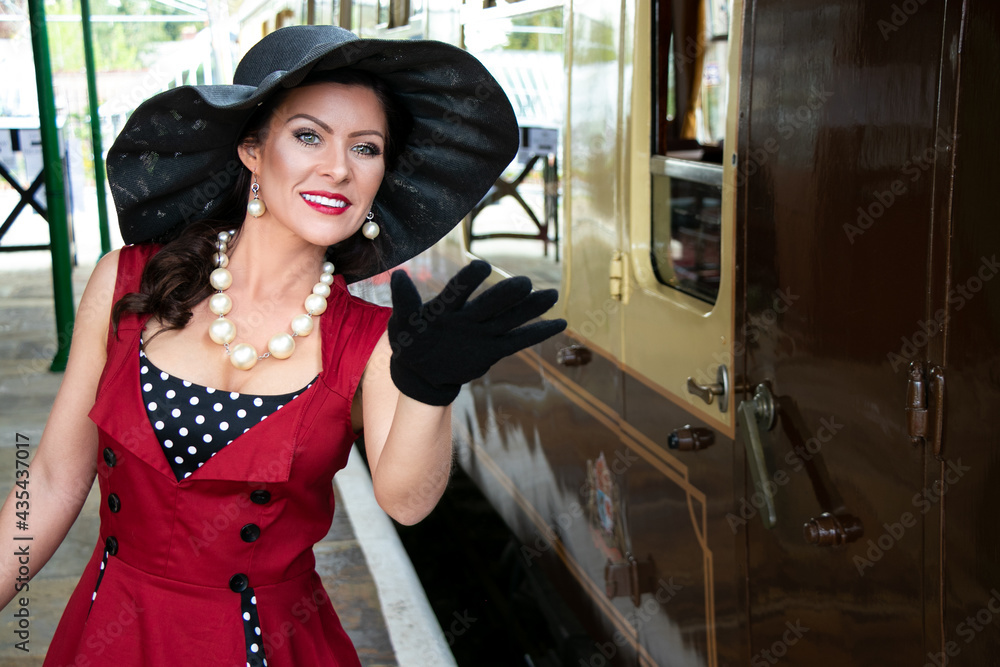 Beautiful woman in vintage red polka dot dress standing on vintage ...