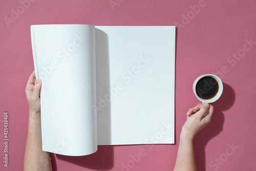 Composition of caucasian woman holding opened book with blank pages and coffee on pink