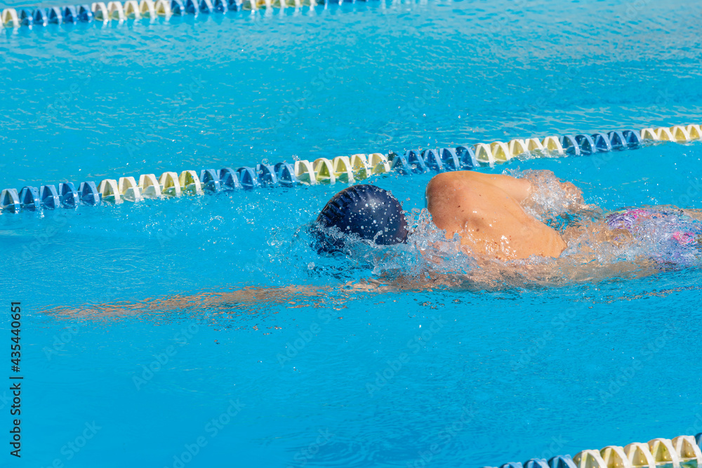 an adult, former swimmer, trains in a public swimming pool