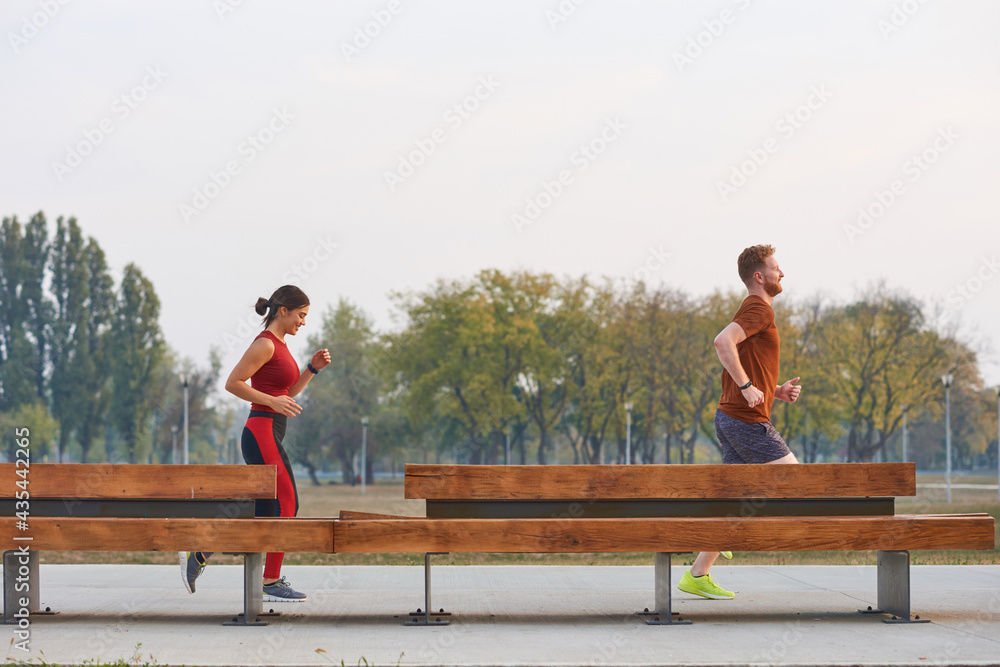 Two young sporty man and woman exercising in urban park. Two young sporty man and woman exercising in urban park.