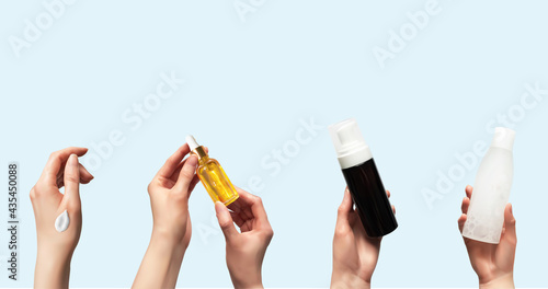 Hands up holding beauty cosmetic products isolated on blue background horizontal banner format 3d realistic vector illustration. Woman takes oil serum, toner bottle, foam cleanser, smear cream
