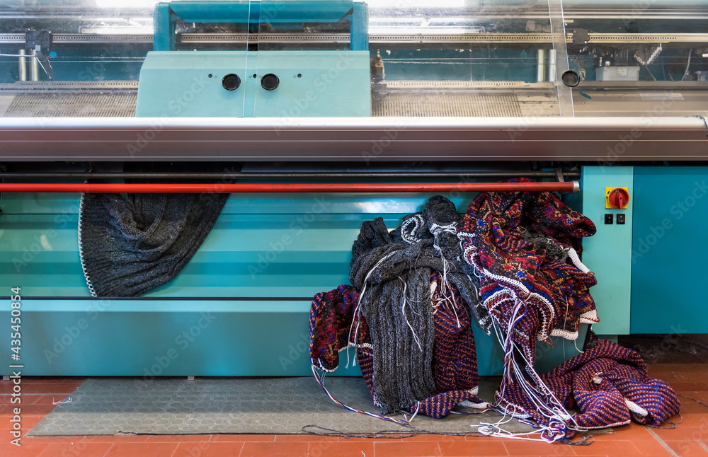 Knitted fabric coming out of a commercial knitting machine Stock Photo