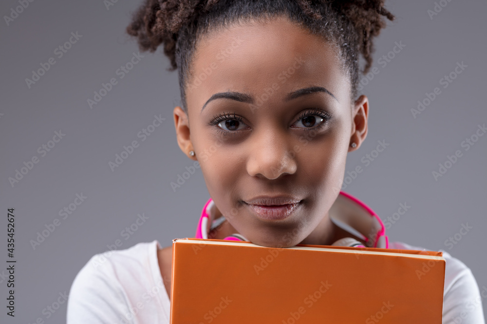 Dedicated serious young black student clutching her books Dedicated serious young black student clutching her books
