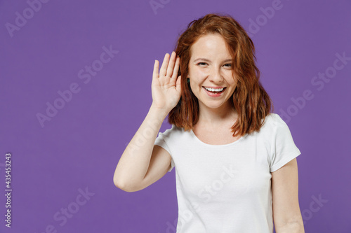 Wallpaper Mural Young smiling curious nosy caucasian woman 20s wear white basic casual t-shirt try to hear you overhear listening intently isolated on dark violet color background studio portrait Lifestyle concept Torontodigital.ca