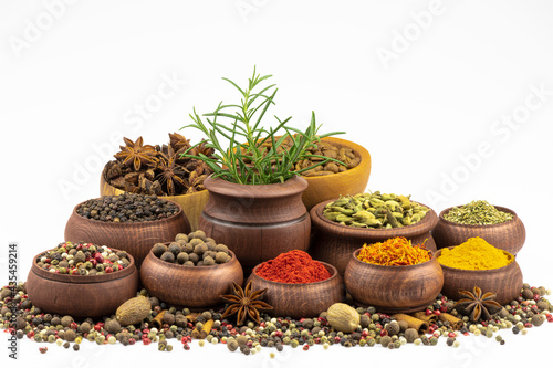 An assortment of spices in wooden dishes on a white background.