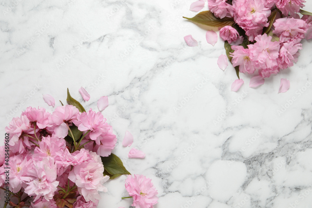 Beautiful sakura tree blossoms on white marble table, flat lay. Space for text Beautiful sakura tree blossoms on white marble table, flat lay. Space for text