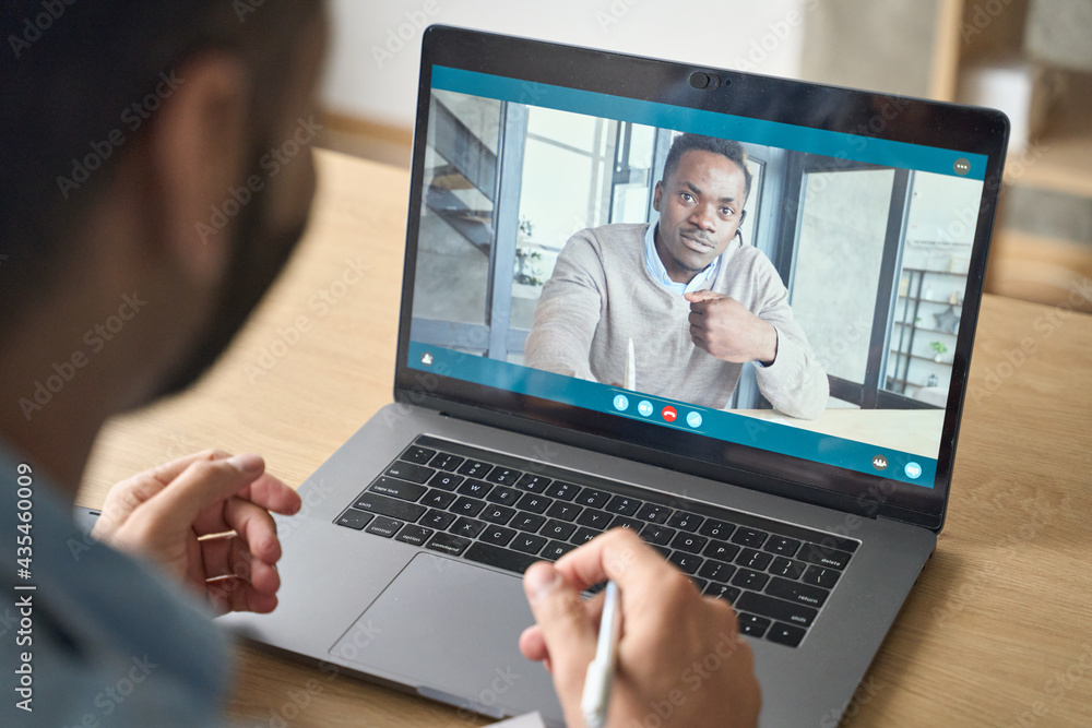 Young indian confident businessman talking to male black man potential employee hiring for job. Virtual video call between employer entrepreneur and manager worker. Remote recruitment work concept. Young indian confident businessman talking to male black man potential employee hiring for job. Virtual video call between employer entrepreneur and manager worker. Remote recruitment work concept.