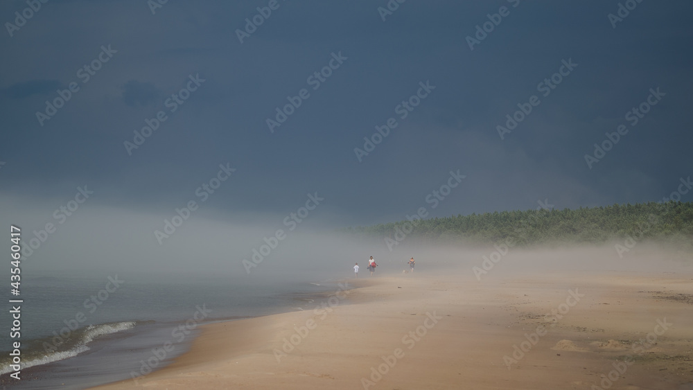 Sunny, hot summer day, but cold water. Fog on the beach, Pavilosta, Latvia.
