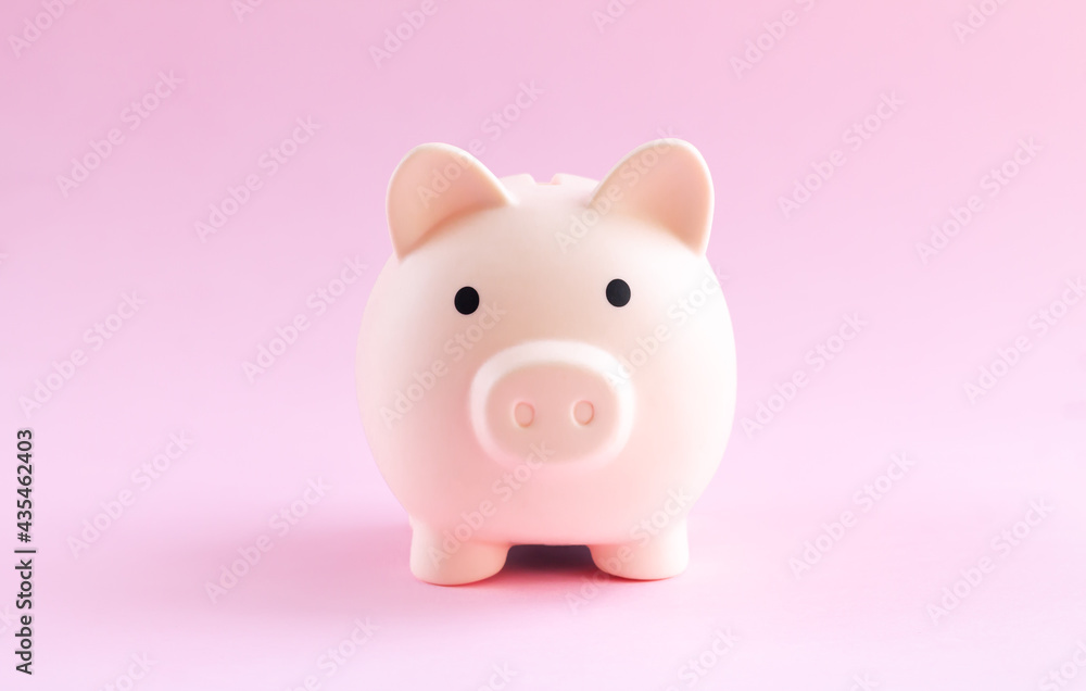 Pink piggy bank on pink background saving money concept