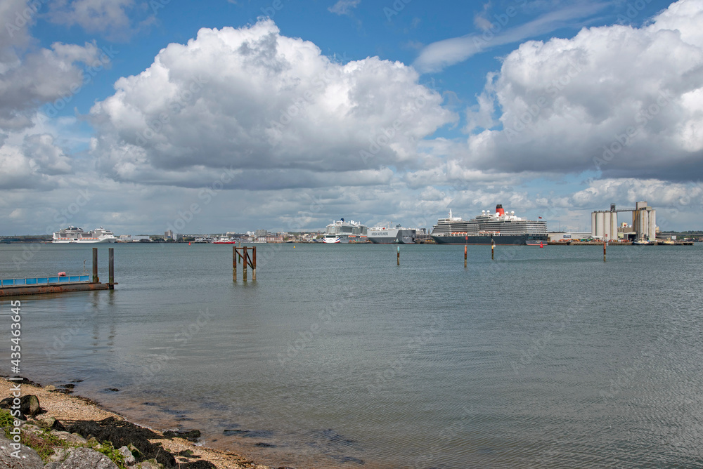 Southampton, England, UK. 2021. The Port of Southampton viewed across Southampton Water with several ships alongside on a bright Spring day.