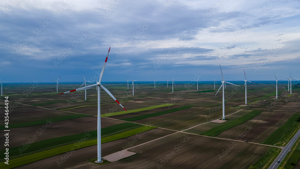 Aerial view of wind farm or wind park, with high wind turbines for generation electricity with copy space. Green energy concept.  Energy Production with clean and Renewable Energy - aerial shot.
