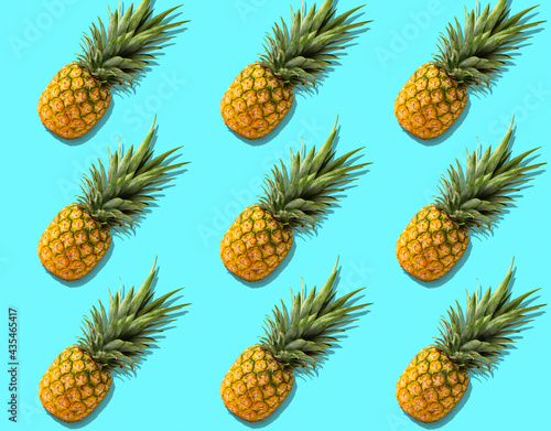 Fruit pattern with organic pineapples on bright azure background