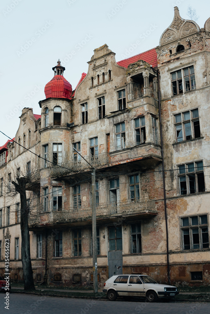 An old historic abandoned house with turrets and decorative ornaments on the facade. One of the main attractions of the city of Sovetsk, Kaliningrad Region