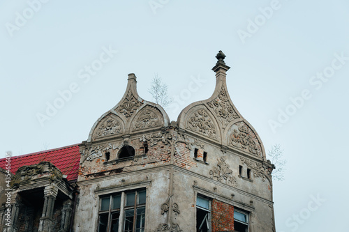 An old historic abandoned house with turrets and decorative ornaments on the facade. One of the main attractions of the city of Sovetsk, Kaliningrad Region photo