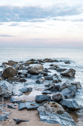 Sea stones boulders sandy shore. Natural landscape.