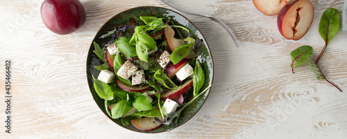 Принти на полотні low-calorie salad with feta, plums and spinach in a green ceramic plate on a lig