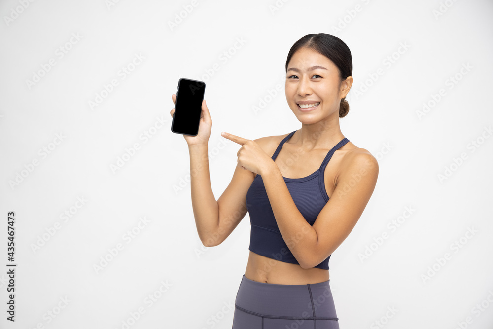 .Portrait of Asian sporty woman showing or presenting mobile phone application on hand isolated over white background .Portrait of Asian sporty woman showing or presenting mobile phone application on hand isolated over white background