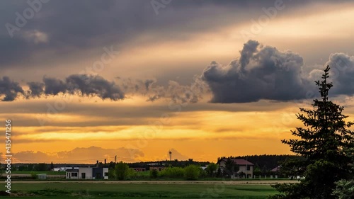 Time lapse of the sunset over green fields with beautiful clouds on the sky.