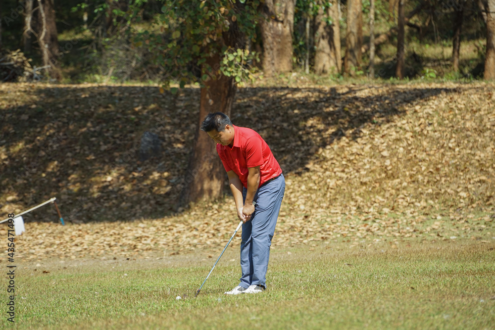 Golfer are playing game golf and hitting go on green grass mountain background. Asia male player game shot in summer. Sport holiday lifestyle concept. Golfer are playing game golf and hitting go on green grass mountain background. Asia male player game shot in summer. Sport holiday lifestyle concept.