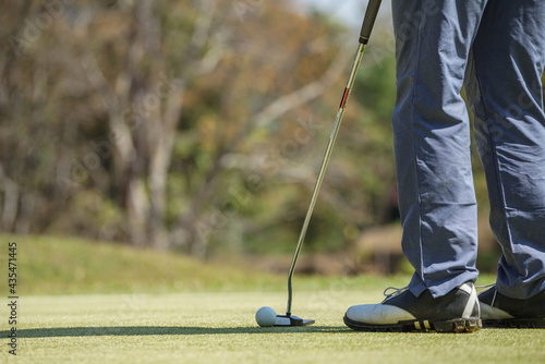 Golfers are putting golf in the evening golf course golf backglound. Golfer hitting golf ball. Sport holiday lifestyle Concept.