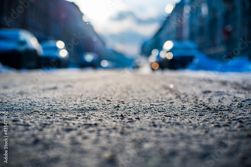 Bright winter sun in a big city, snowy road. View from the road level
