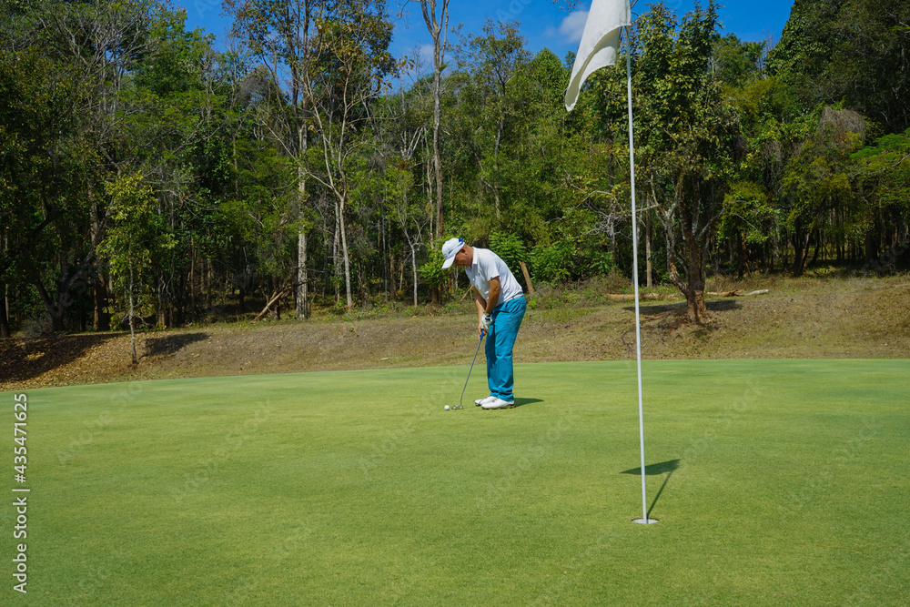 Obraz premium Golfers are putting golf in the evening golf course golf backglound. Golfer hitting golf ball. Sport holiday lifestyle Concept.
