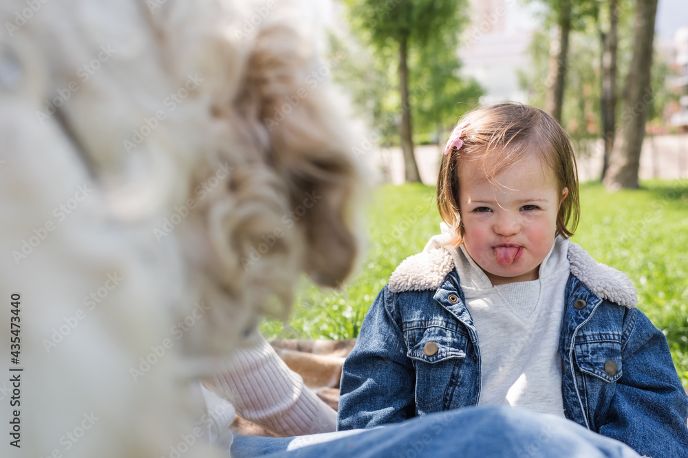 autistic child sticking out tongue near dog on blurred foreground autistic child sticking out tongue near dog on blurred foreground