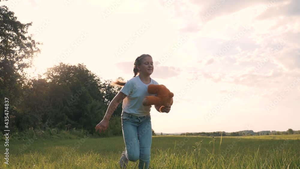 Little girl with a toy teddy bear in park. Cute girl with a teddy bear in a green field. Lonely girl with a toy teddy bear in park in green field.Teddy bear in the hands of a girl in the park Little girl with a toy teddy bear in park. Cute girl with a teddy bear in a green field. Lonely girl with a toy teddy bear in park in green field.Teddy bear in the hands of a girl in the park