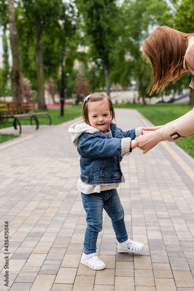 autistic child in denim clothes holding hands of mother in park autistic child in denim clothes holding hands of mother in park