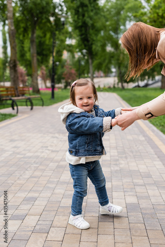 autistic child in denim clothes holding hands of mother in park © LIGHTFIELD STUDIOS