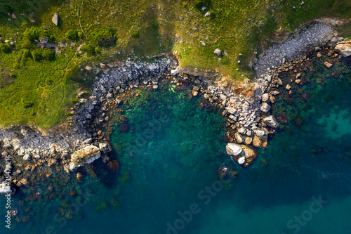 Island with rocky coast and blue sea. Drone picture.