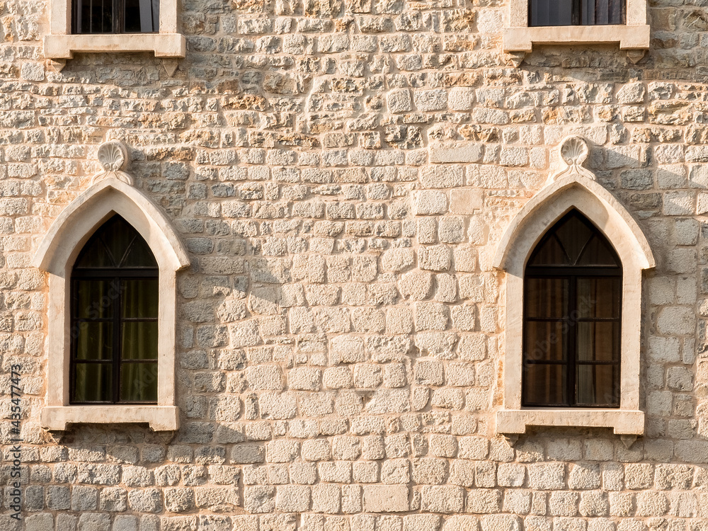 Detail of the facade of a building with two lancet windows. Mediterranean medieval architecture. Detail of the facade of a building with two lancet windows. Mediterranean medieval architecture.