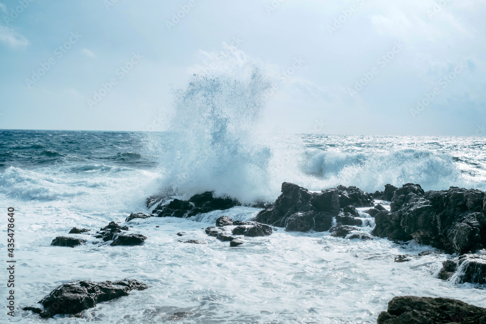 Waves rush onto the rocks. Stormy weather. Powerful blow of the sea wave.