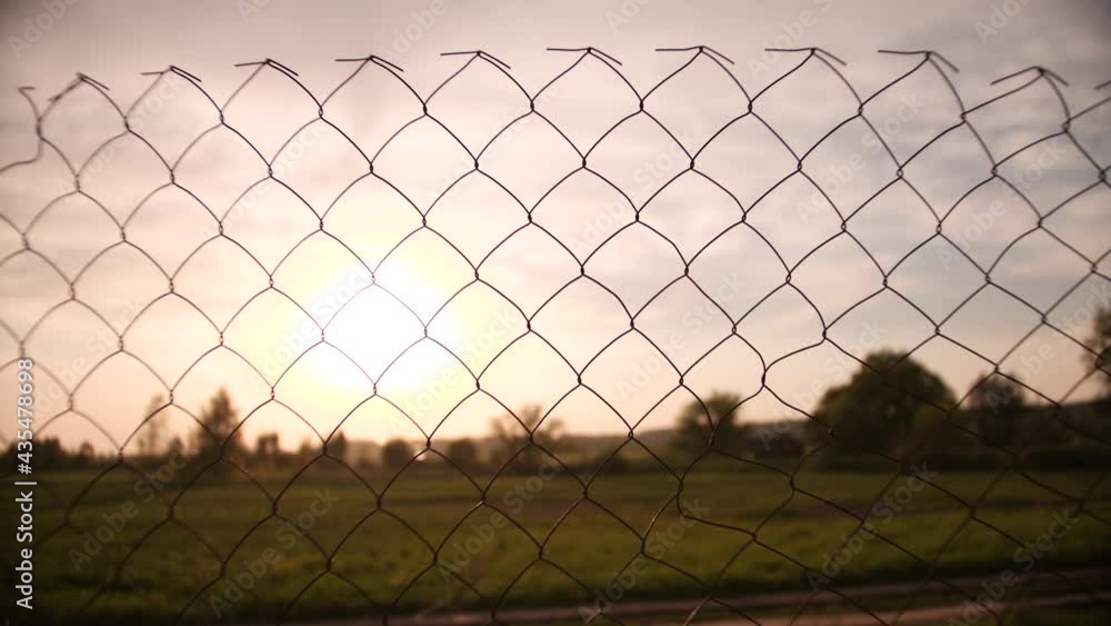 Summer sunset scenery behind old wire fence Summer sunset scenery behind old wire fence