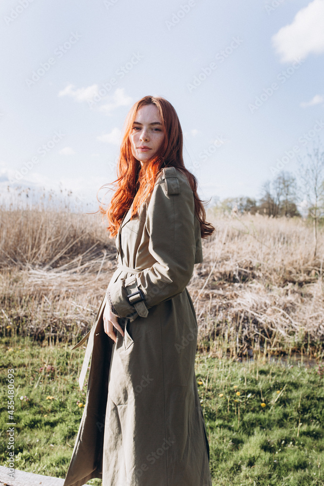 Red hair girl with freckled face outdoors near the lake. Natural beauty, eco lifestyle, nature concept Red hair girl with freckled face outdoors near the lake. Natural beauty, eco lifestyle, nature concept