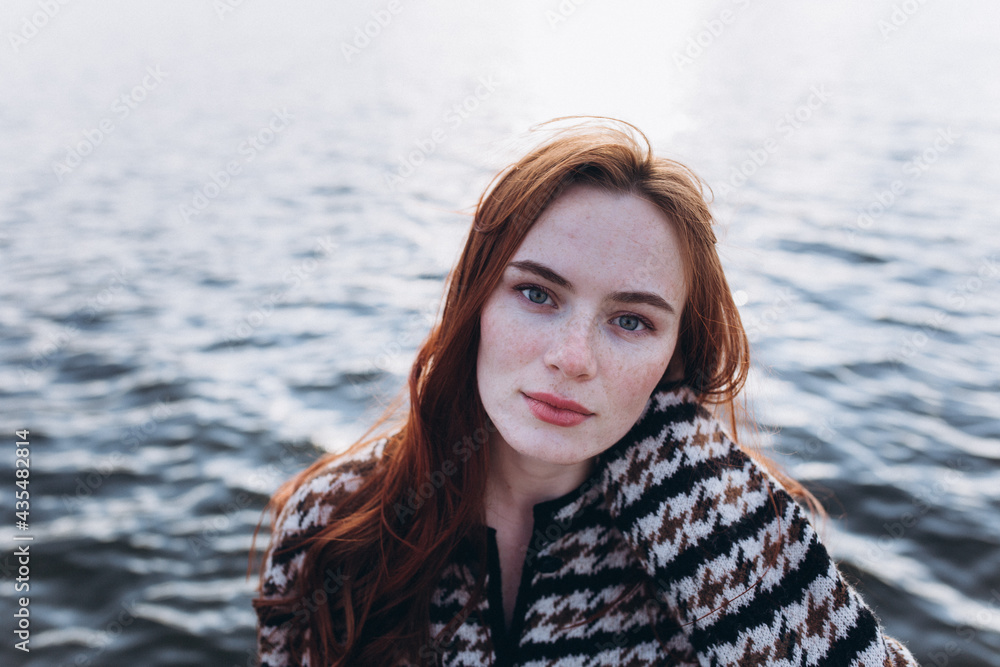 Red hair girl with freckled face outdoors near the lake. Natural beauty, eco lifestyle, nature concept Red hair girl with freckled face outdoors near the lake. Natural beauty, eco lifestyle, nature concept