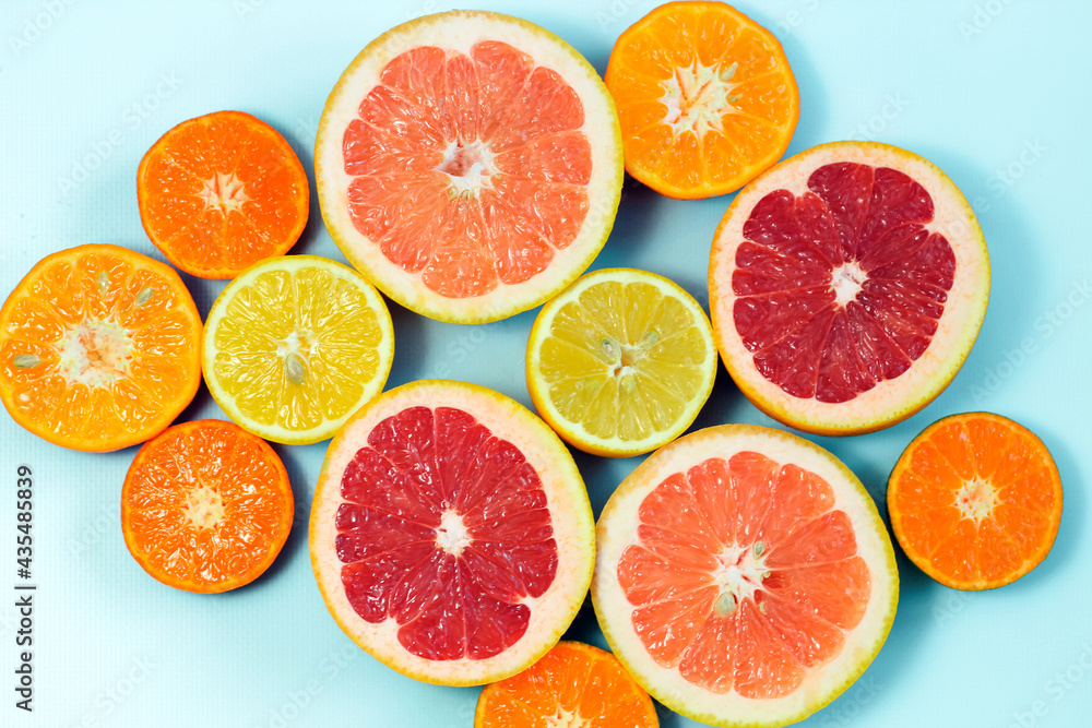 Sliced citrus on a blue background. Grapefruit, lemon, tangerine. Sliced citrus on a blue background. Grapefruit, lemon, tangerine.