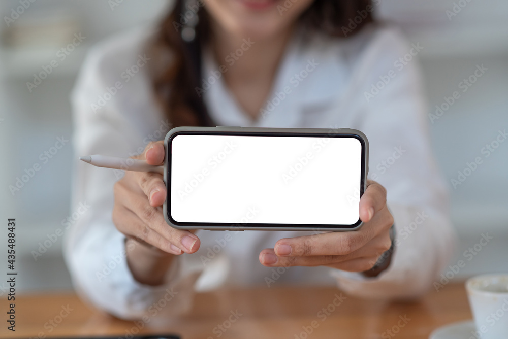 Close-up of a businesswoman hand showing a smartphone blank white screen. Mock up.
